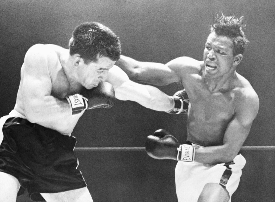 (Original Caption) 4/18/1952-Chicago, IL: Middleweight champion Sugar Ray Robinson throws a right over the head of Rocky Graziano (L), who scores w...