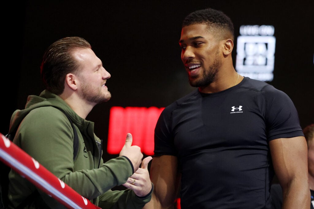 Ben Davison speaks to Anthony Joshua at a press conference