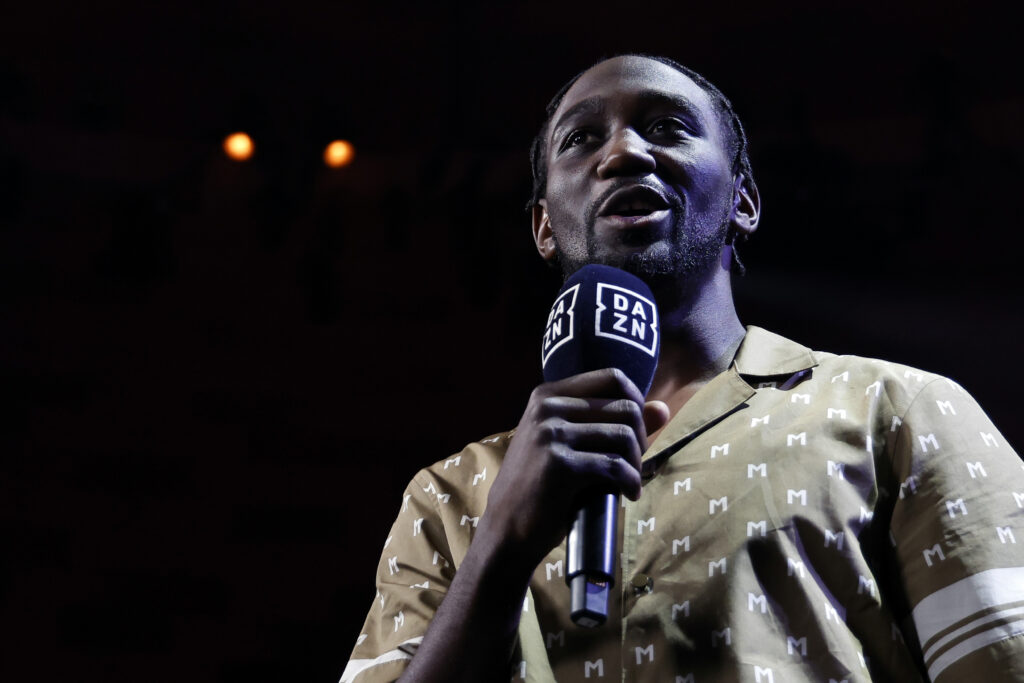 Terence Crawford speaking into microphone wearing a patterned shirt