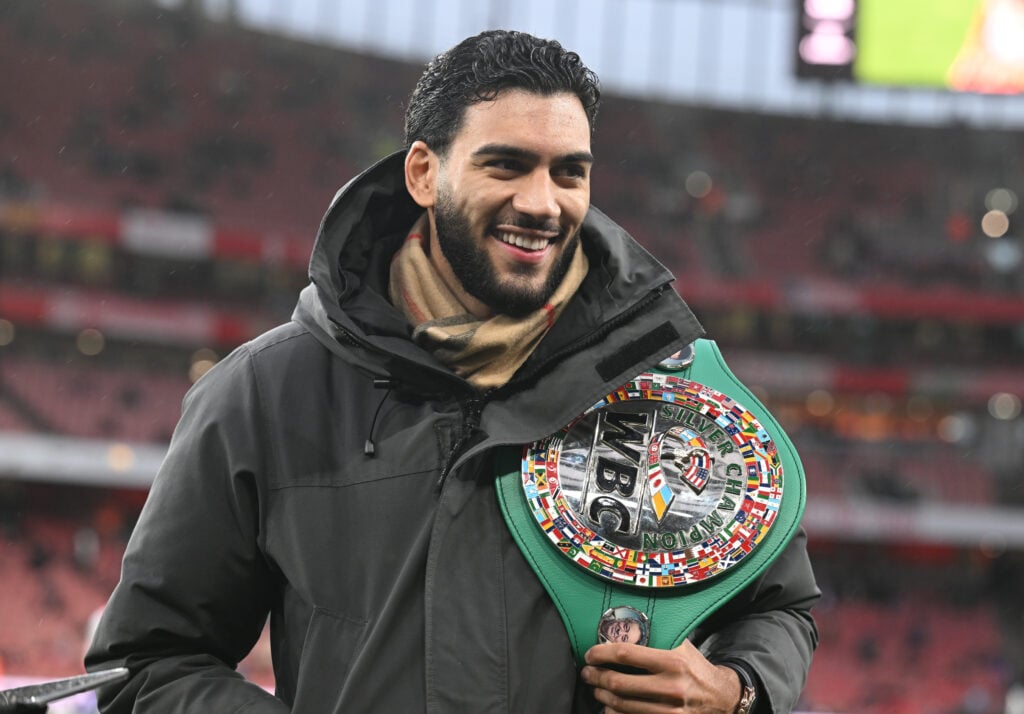 Hamzah Sheeraz smiling with belt over his shoulder in football stadium