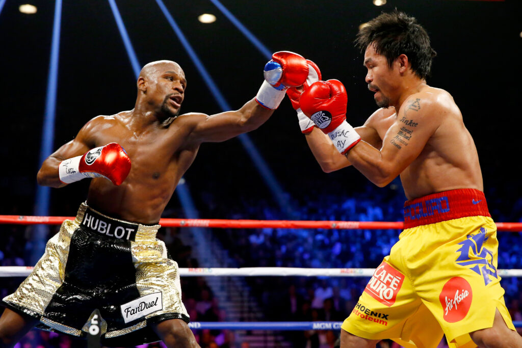Floyd Mayweather Jr jabs Manny Pacquiao who blocks the punch with his right hand