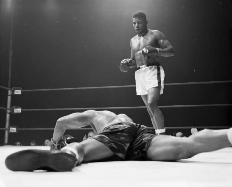 Archie Moore decorates the canvas face down after taking a left hook from Floyd Patterson in the 5th round of their heavyweight title bout. A momen...