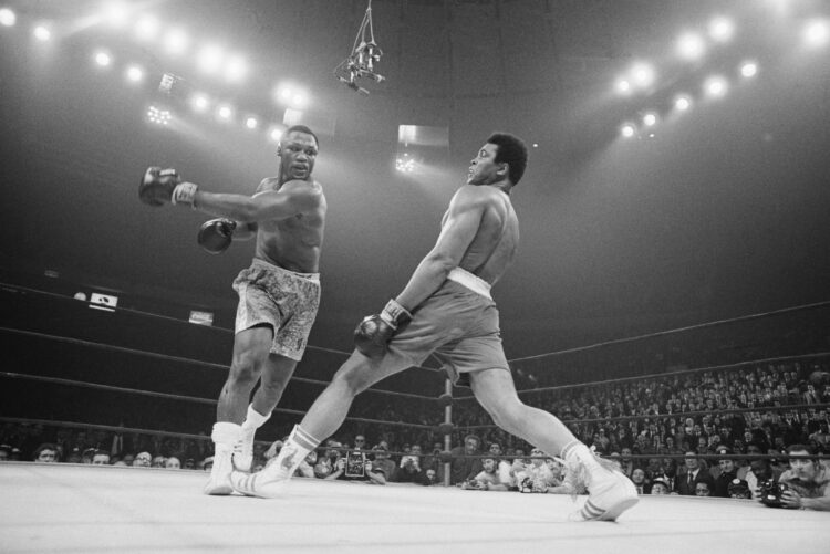 Boxer Muhammad Ali steps away from a punch thrown by boxer Joe Frazier during their heavyweight title fight at Madison Square Garden in 1971. Frazi...