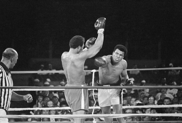 Muhammad Ali (r) punches George Foreman (c) during their world heavyweight title boxing match in 1974, while a referee looks on.