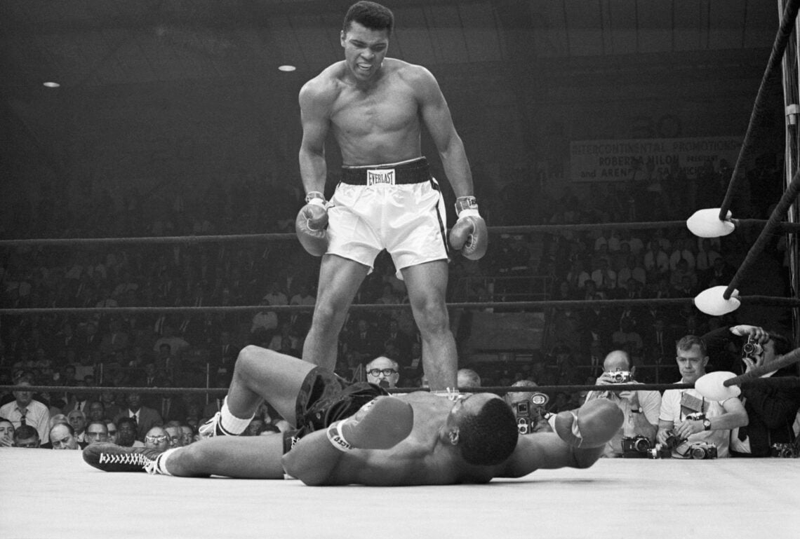 Heavyweight champion Muhammad Ali stands over Sonny Liston and taunts him to get up during their title fight. Ali knocked Liston out in one minute ...
