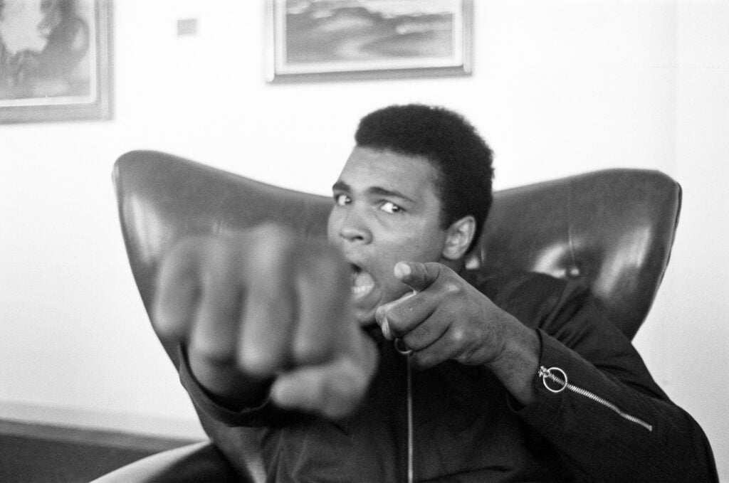 Muhammad Ali poses in chair