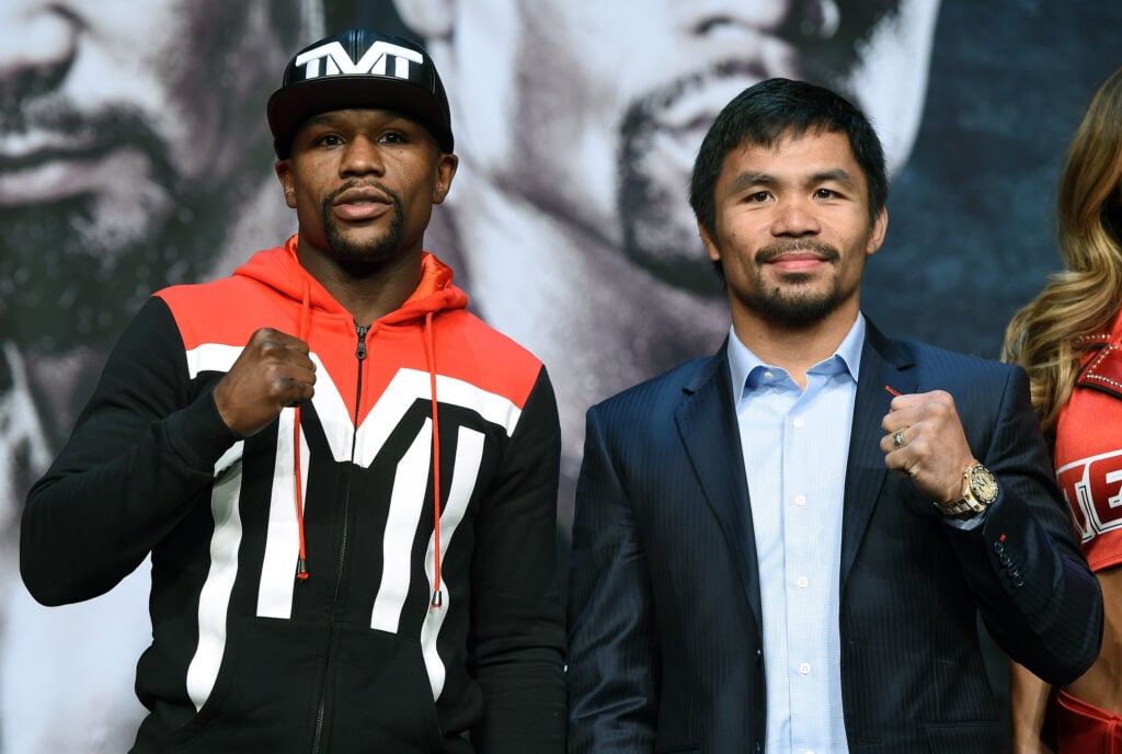 Floyd Mayweather and Manny Pacquiao pose with their fist up as they stand side-by-side at the pre fight press conference.