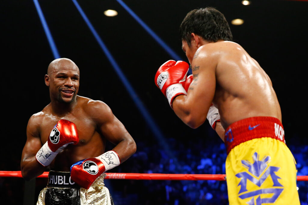 Floyd Mayweather Jr. smirks as he stands opposite Manny Pacquiao