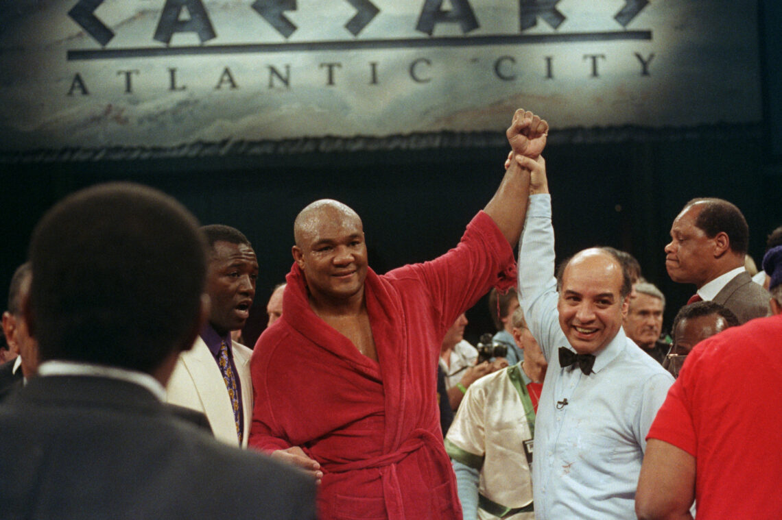 (Original Caption) 1/15/1990-Atlantic City, New Jersey- Referee Joe Cortez raises George "The Preacher" Foreman's hand declaring him the winner by ...