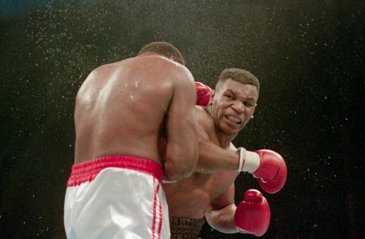 (Original Caption) 1/22/1988-Atlantic City, NJ Ferocious faced Mike Tyson lands the knockout punch to the jaw of challenger Larry Holmes during fou...
