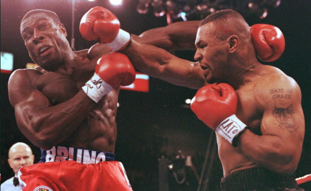 Mike Tyson of the US (R) lands a right cross to th