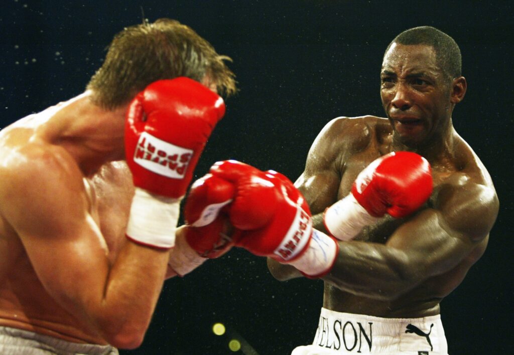 Johnny Nelson punches his opponent during 2004 WBO fight.