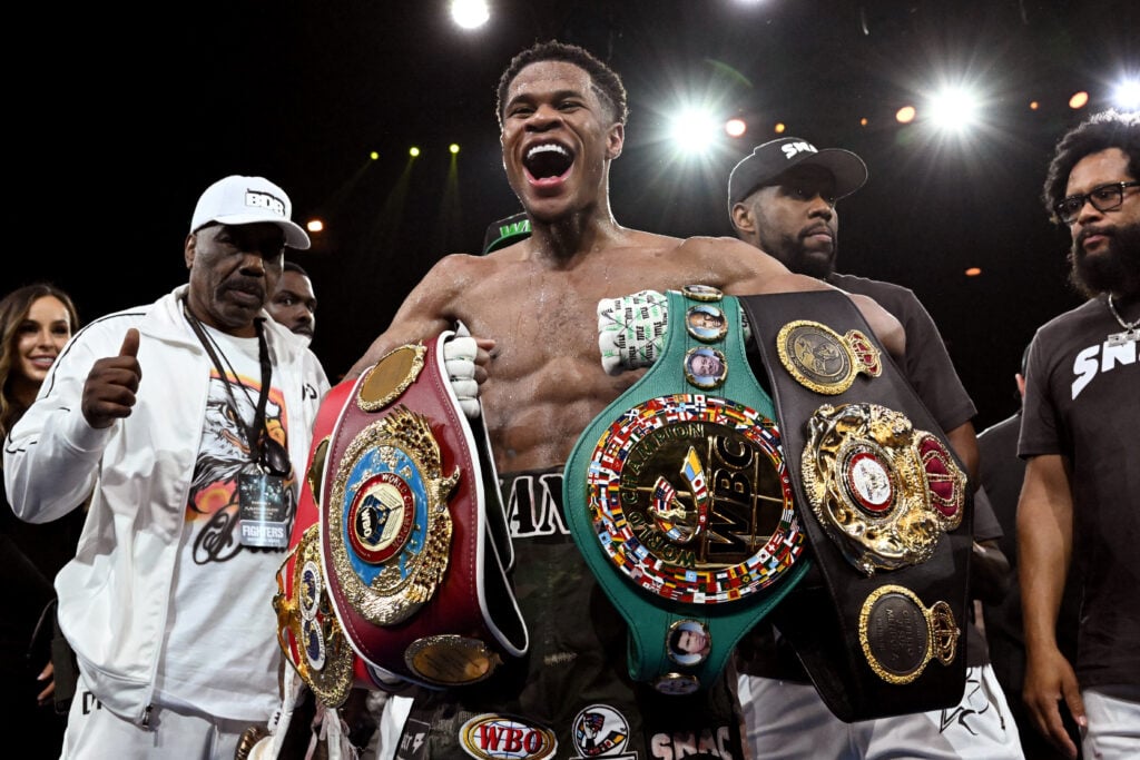 Devin Haney holding his belts
