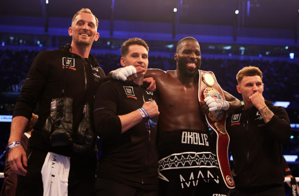 Lawrence Okolie celebrating with his team after beating Dilan Prasovic