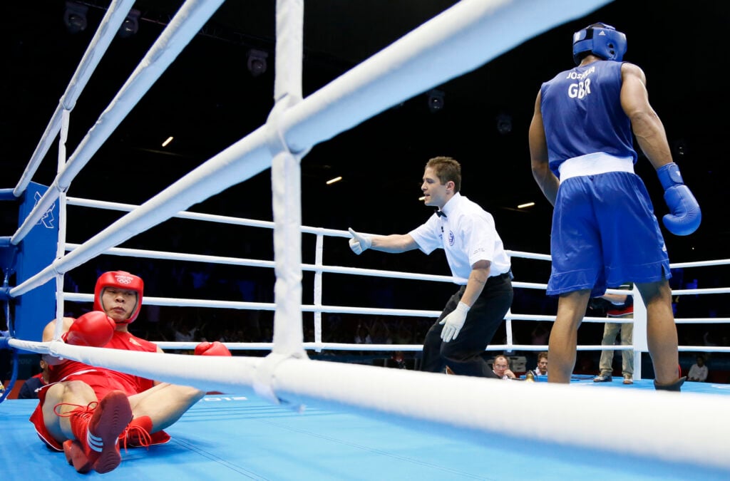 The referee counts over the fallen Zhile
