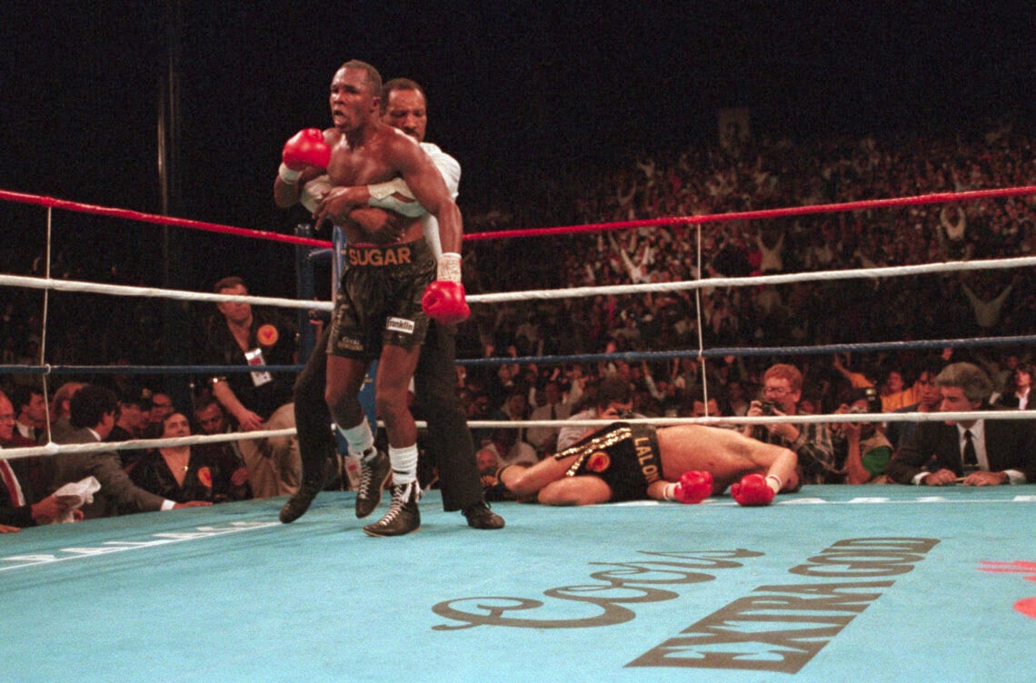 Referee Richard Steele restrains Sugar Ray Leonard in the ninth round following his knockdown of Donny Lalonde. Sugar Ray defeated Lalonde by KO in...