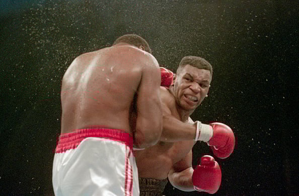 Mike Tyson looking at his opponent after landing punch on Larry Holmes