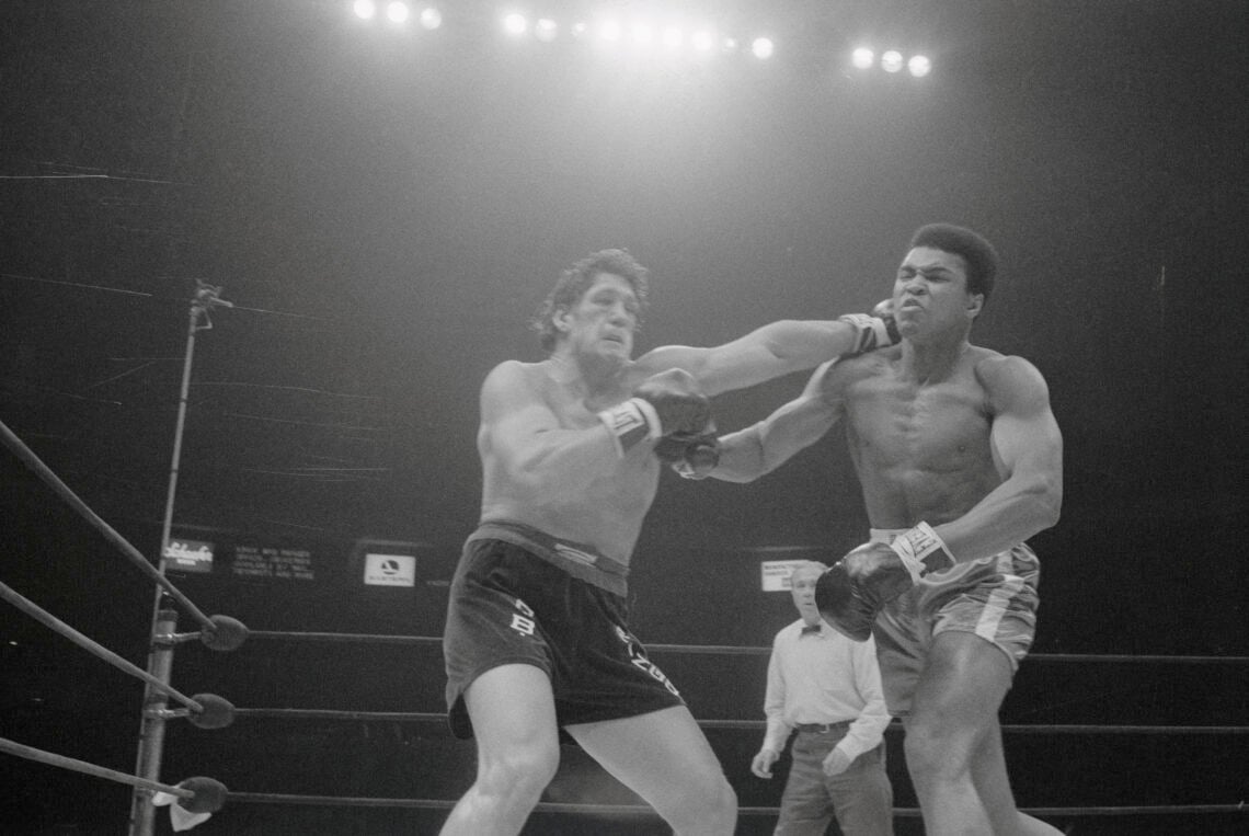 (Original Caption) Oscar Bonavena (left) slams Cassius Clay with a powerful left during their fight here late December 7th. Despite moments like th...