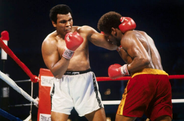 (Original Caption) Muhammad Ali holds Leon Spinks' neck with one hand while preparing to hit him with the other hand.