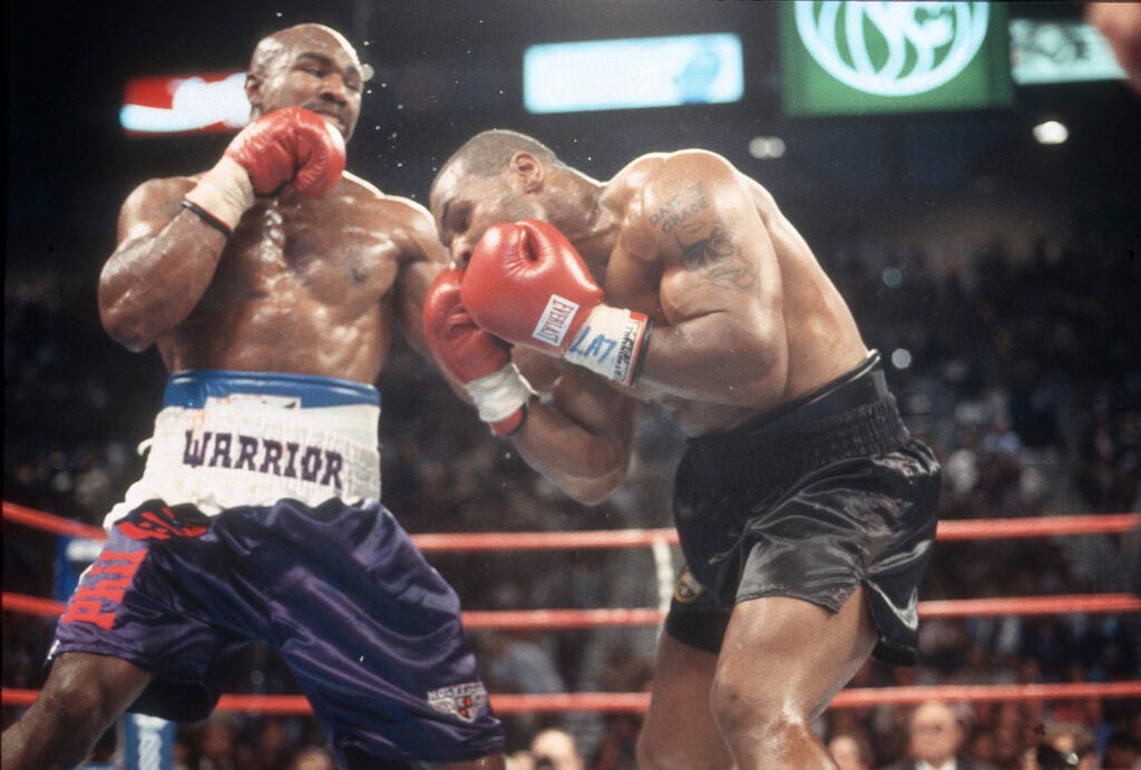 Evander Holyfield punches Mike Tyson as Tyson is bent over during their rematch iin 1997
