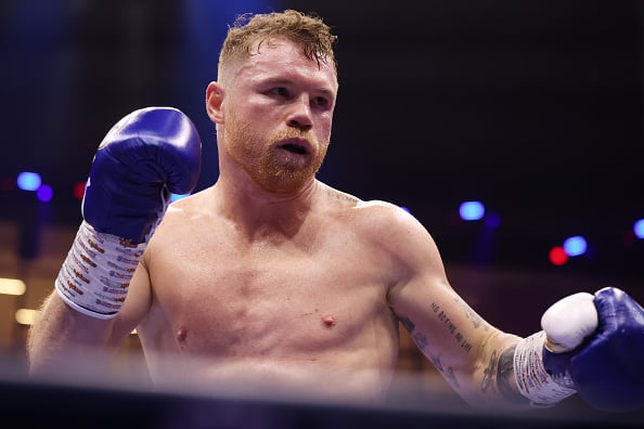 Close-up of Canelo Alvarez as he tracks down William Scull during their super middleweight boxing match, he has blue gloves on