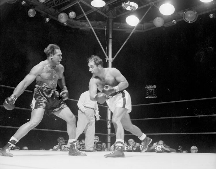 (Original Caption) Glaring Moment. New York, New York: Rocky Marciano (right) and Archie Moore glare at each other in the wild sixth round just bef...