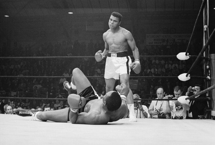 Boxer Muhammad Ali stands over boxer Sonny Liston after knocking him down during the first round of their match. Clay won the May 25, 1965 fight an...