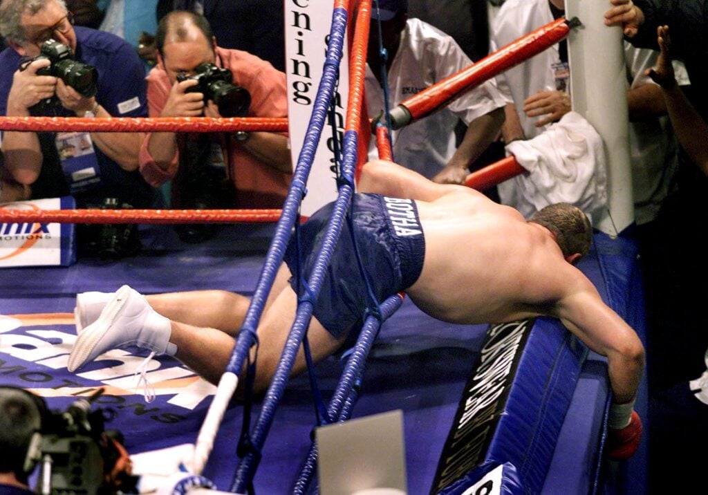 Francois Botha of South Africa is nearly out of the ring by Lennox Lewis