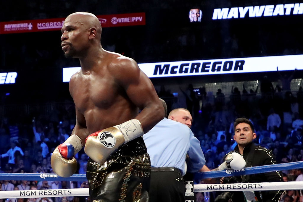 Floyd Mayweather Jr. after stopping Conor McGregor who can be slightly seen leaning on the ropes in the background