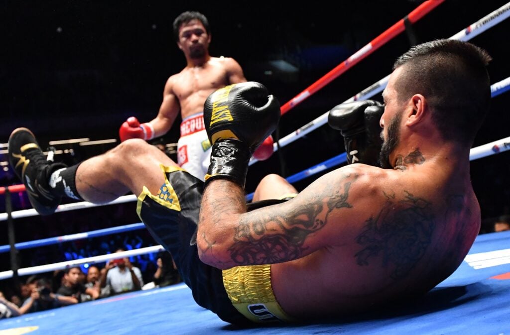 Close up of Lucas Matthysse after being dropped by Manny Pacquiao, who stands in the background