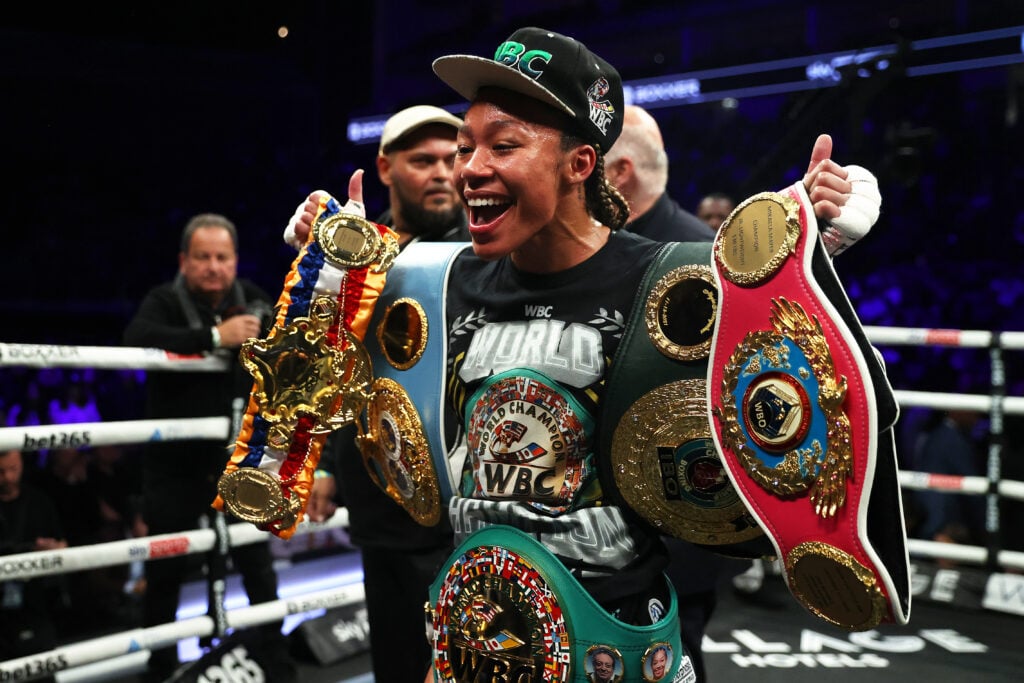 Alycia Baumgardner poses with her belts after beating Mikaela Mayer