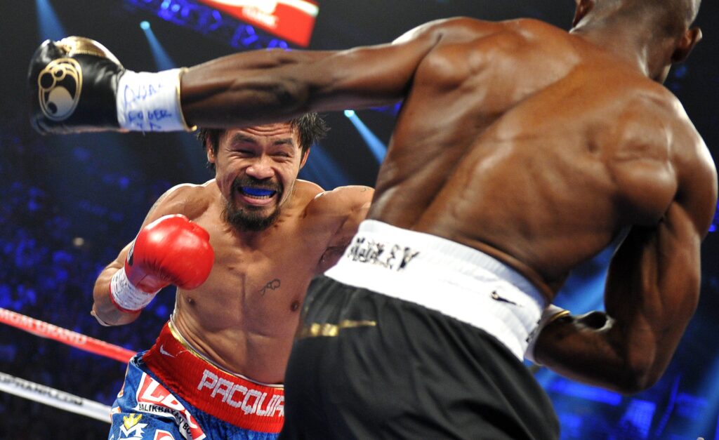 Manny Pacquiao fires a left hand at Tim Bradley, whose back is to the camera