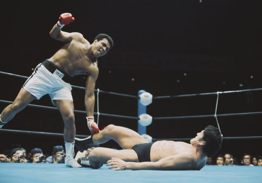Muhammad Ali winces in pain after being kicked by Antonio Inoki in their "War of the Worlds" fight in 1976