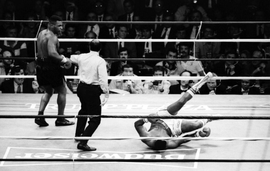 Mike Tyson knocks down Larry Holmes during their heavyweight boxing match