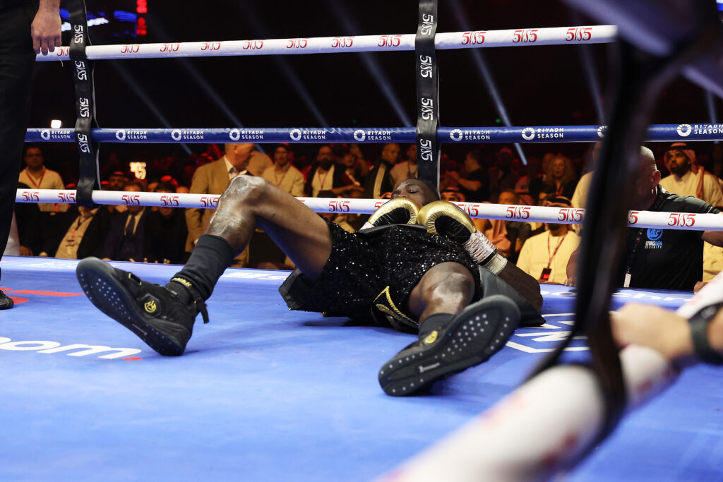 Deontay Wilder lying on the floor near the corner of the ring after being knocked down by Zhilei Khang