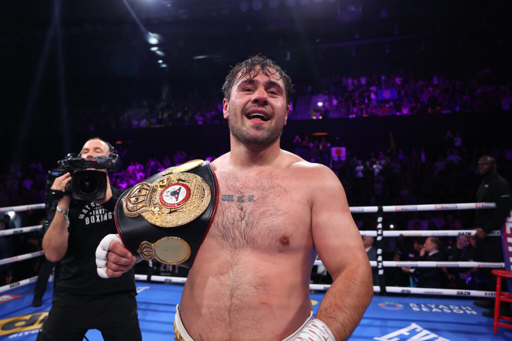 Dave Allen celebrates defeating Johnny Fisher with a belt draped over his shoulder