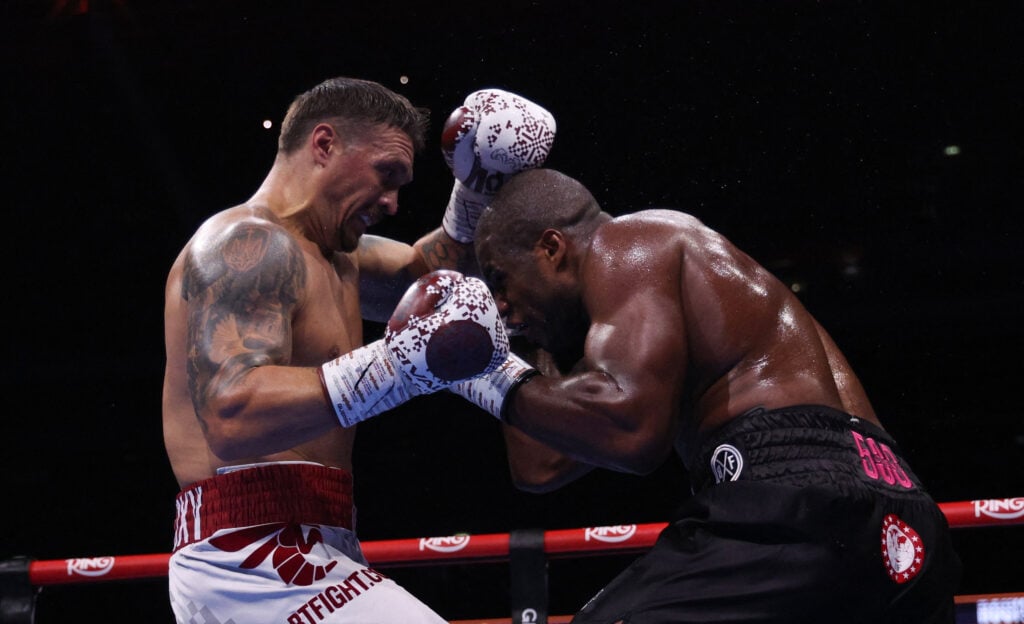 Oleksandr Usyk holds up his hands as Dubois rushes in