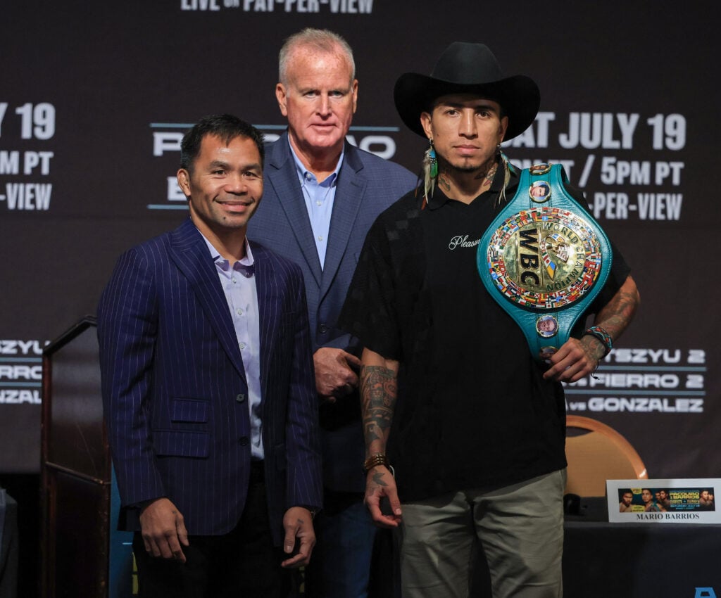 Manny Pacquiao Mario Barrios pose on stage in front of TGB Promotions president at the press conference for their fight
