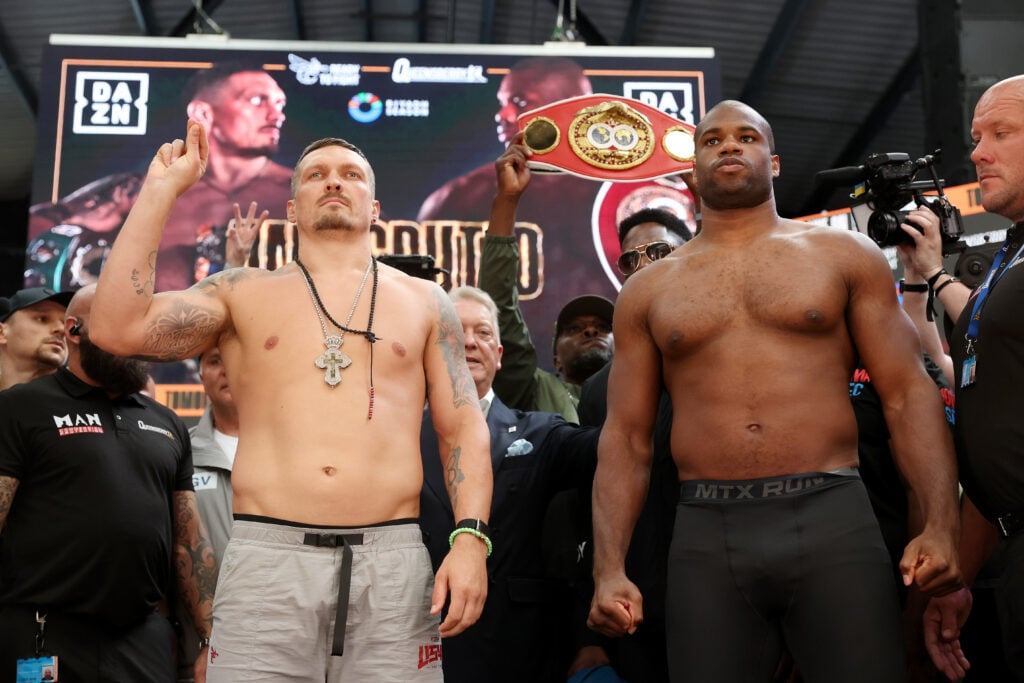 Oleksandr Usyk poses with one fist up beside Daniel Dubois after their weigh in