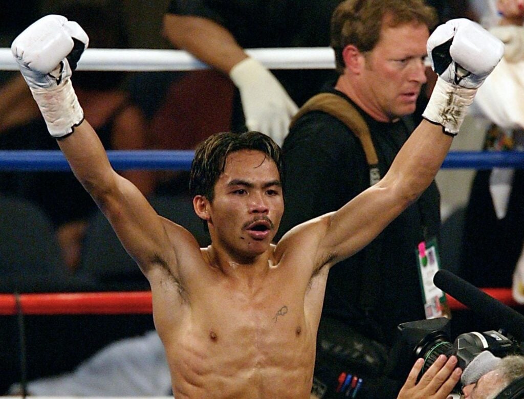 Manny Pacquiao of the Phillipines celebrates his TKO win over Jorge Julio with his arms in the air