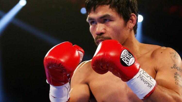 Manny Pacquiao with red gloves on and his hands in high guard during a fight