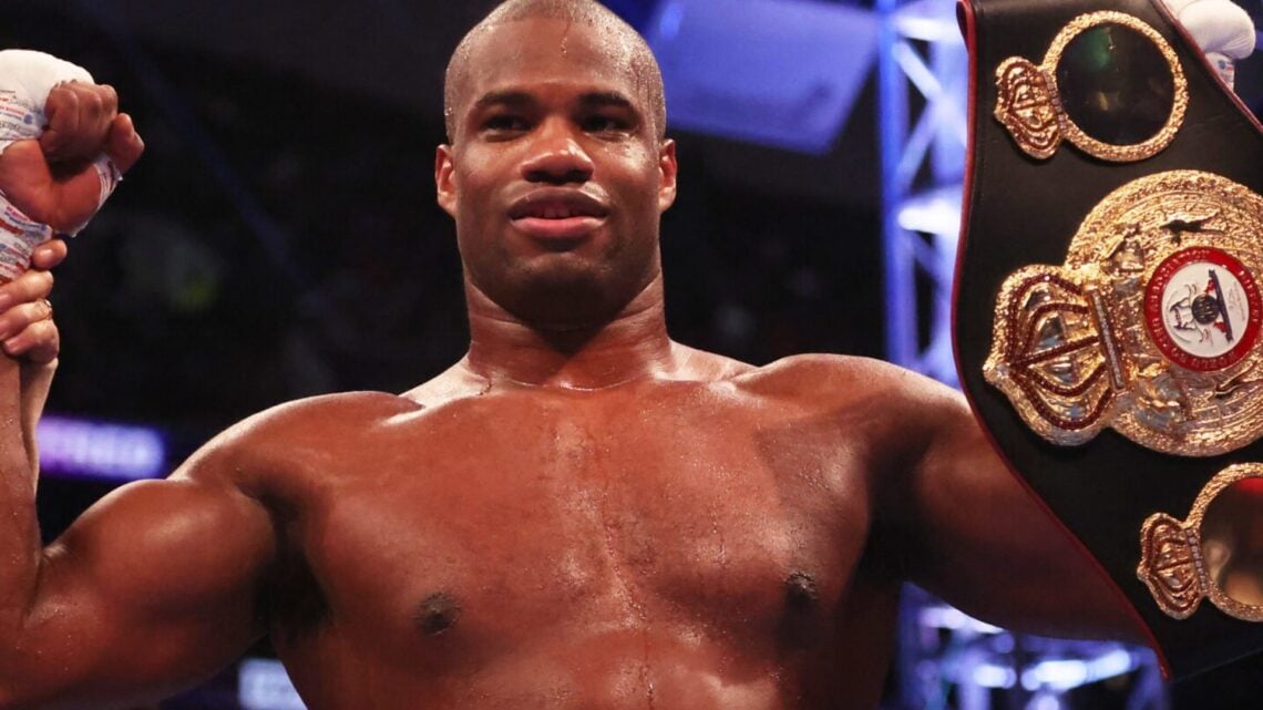Daniel Dubois with a belt in his hand as he celebrates a win