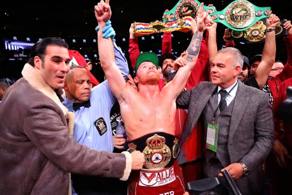 Canelo Alvarez celebrates with his title belts after knockout out Rocky Fielding
