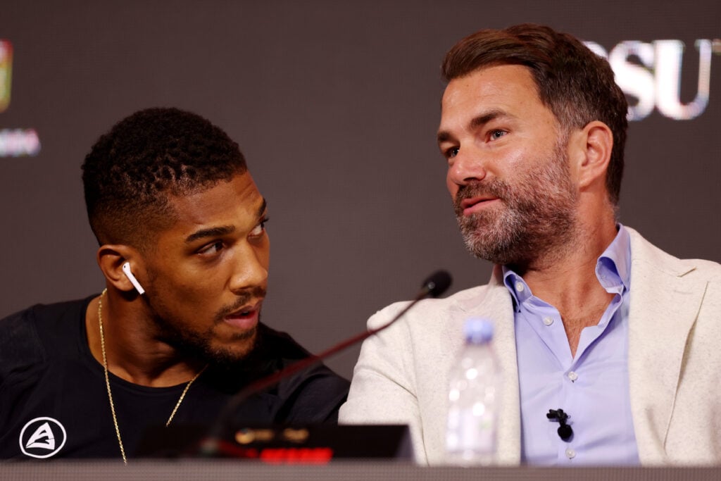 Anthony Joshua looking at Eddie Hearn at a press conference
