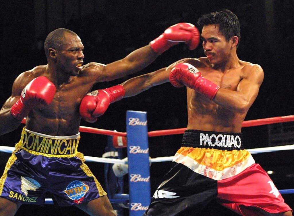 Manny Pacquiao throws a right at Agapito Sanchez's body whilst Sanchez throws at his head