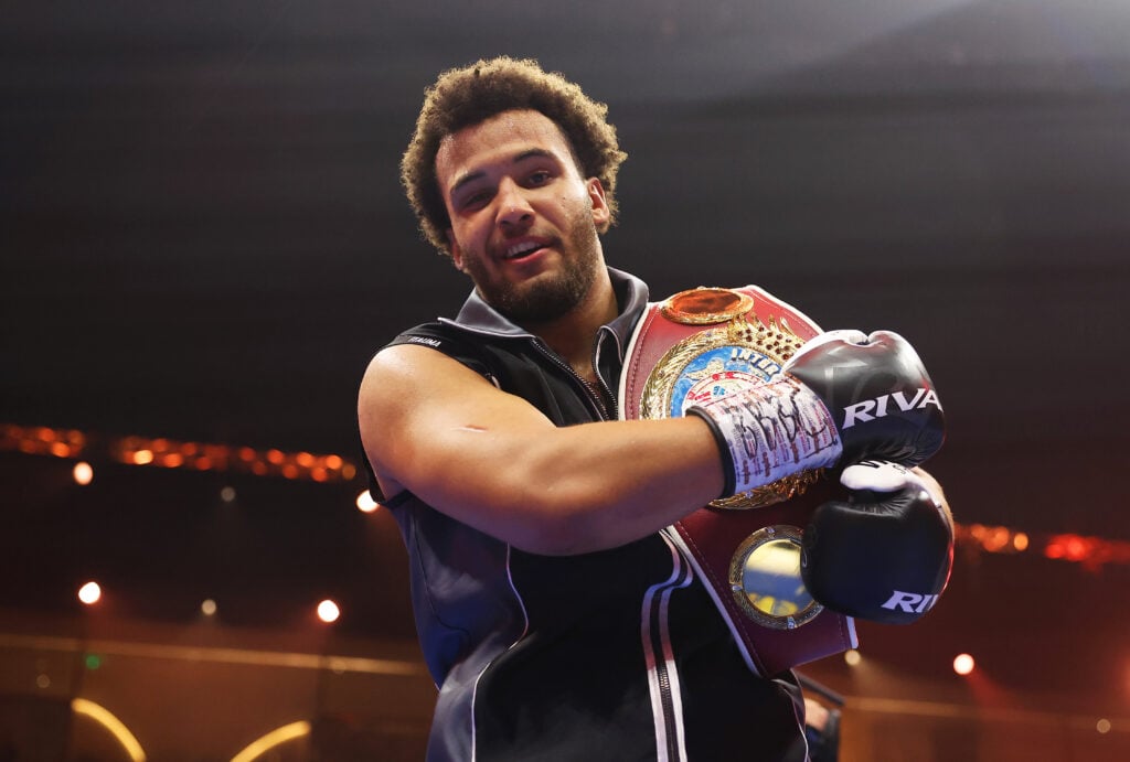 Moses Itauma celebrates his win over Demsey McKean and holds a belt