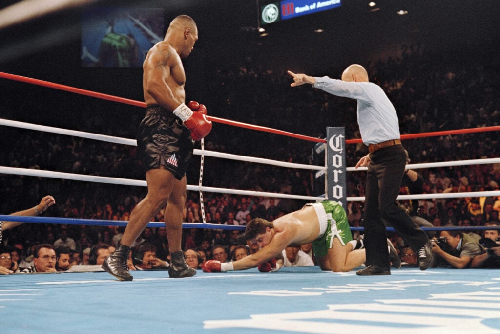 Mike Tyson stands over Peter McNeeley after knocking him down in his first fight since prison