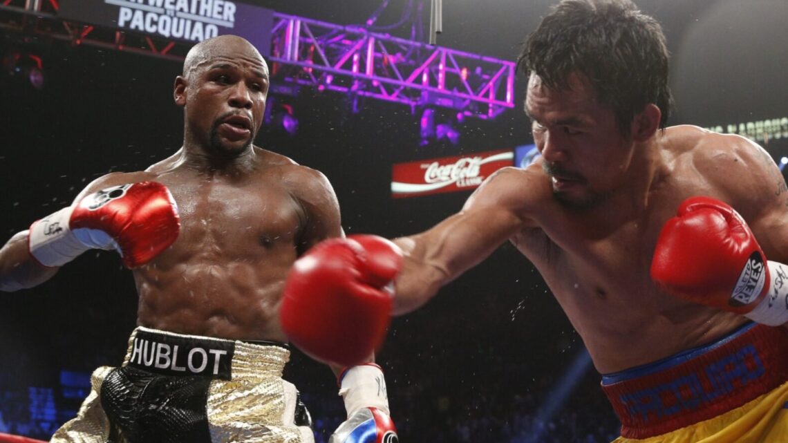 Floyd Mayweather looks on as Manny Pacquiao misses a right hand