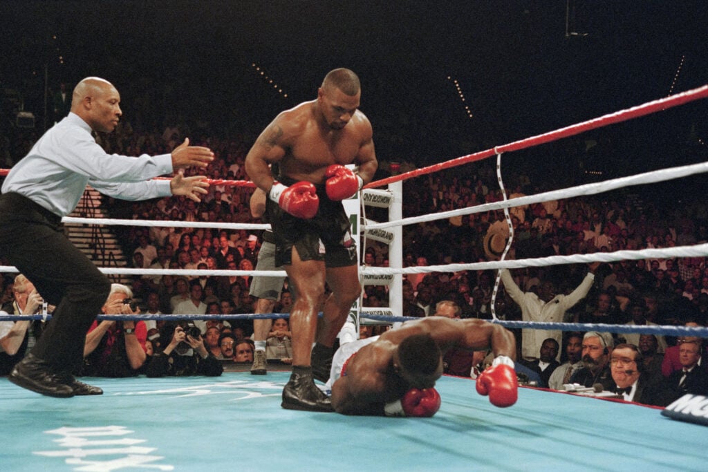 Mike Tyson stands over Bruce Seldon after knocking him down