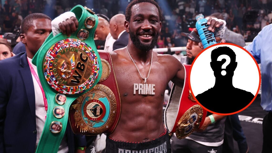 Terence Crawford holds up his title belts in the ring with a mystery insert to his right